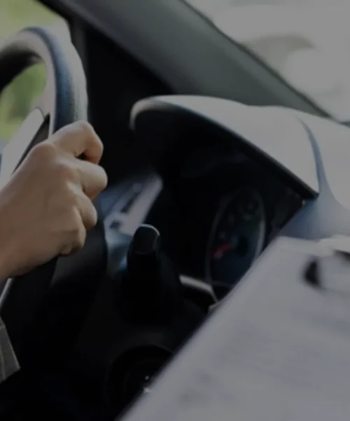 Close-up of driver’s hand on steering wheel