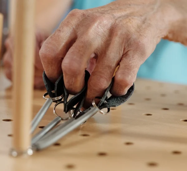 Hands using tools on a wooden surface